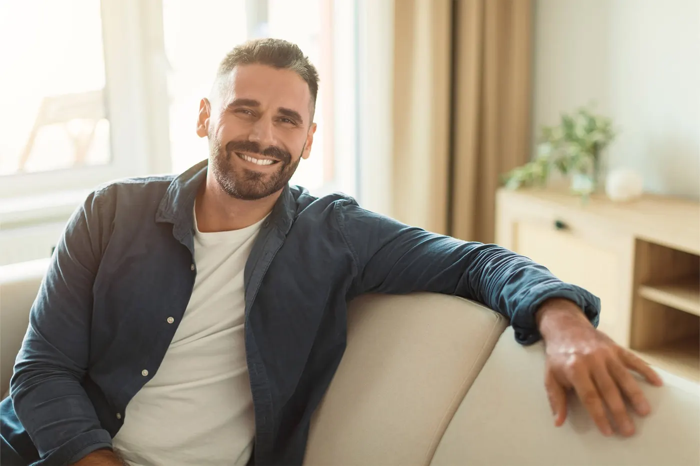 Smiling man relaxing on a sofa at home
