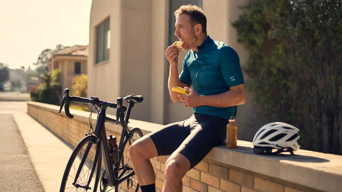 Cyclist in his forties resting with a snack after a long ride