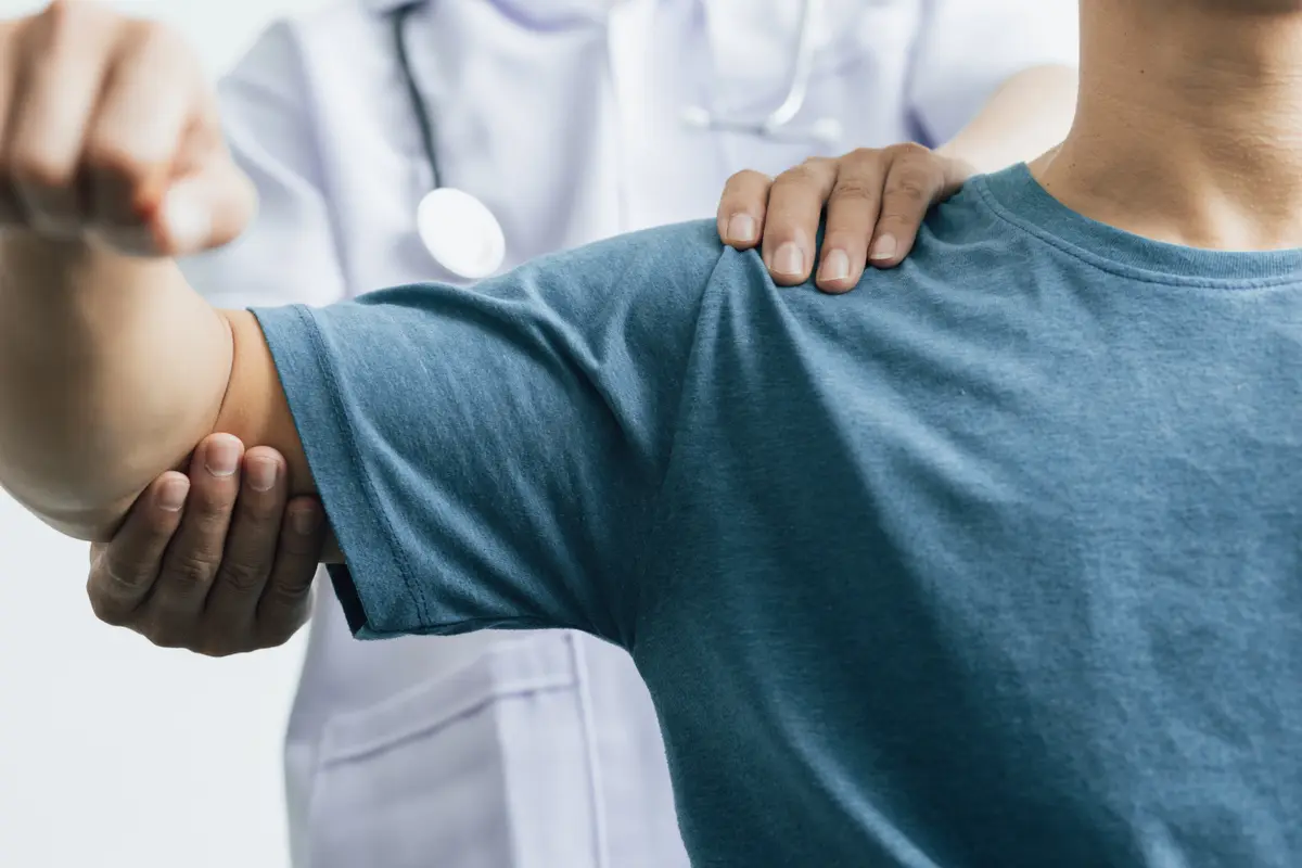 Clinician checking a man's shoulder
