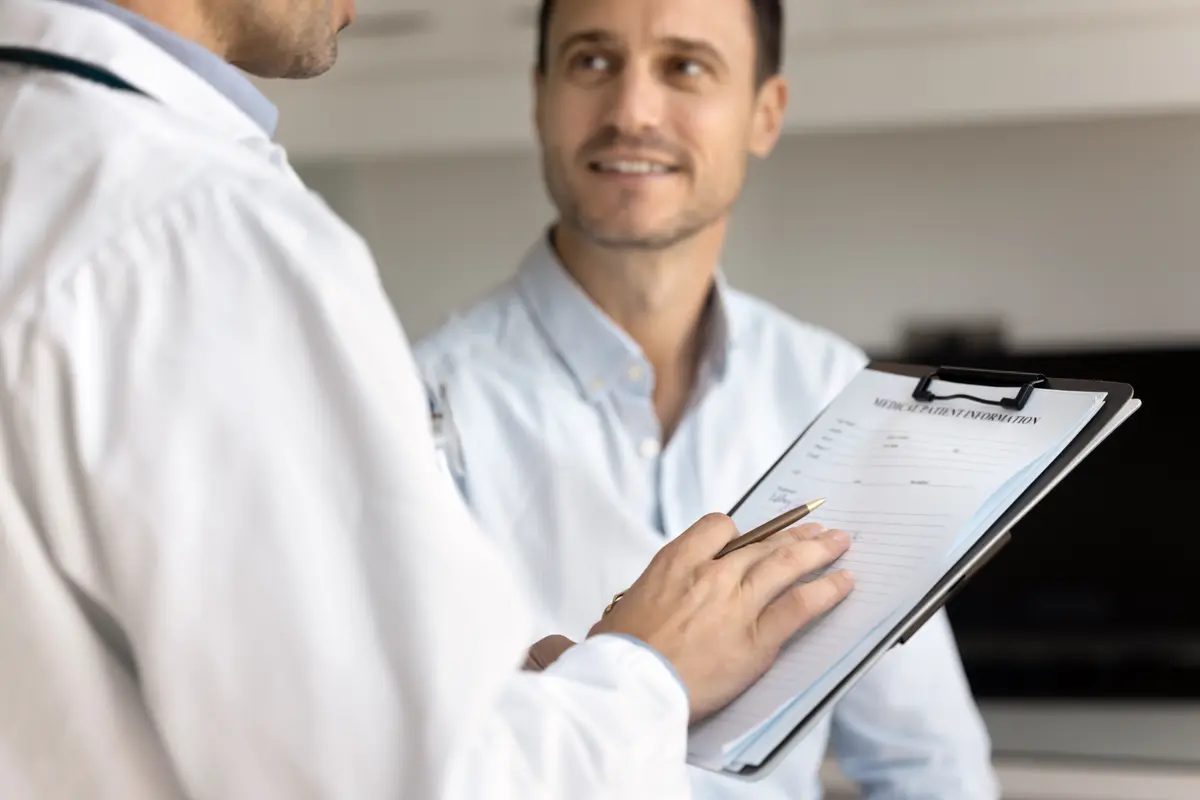 Clinician reviewing an intake form with a male patient