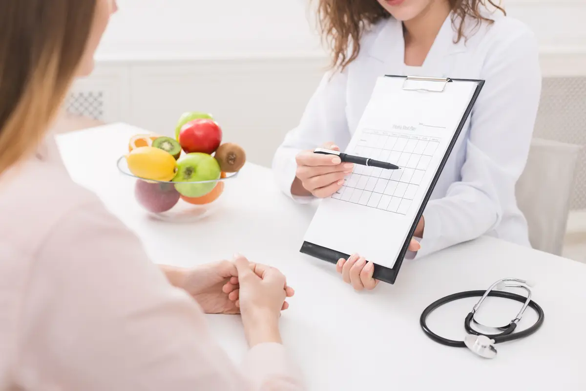 Clinician with a clipboard and a bowl of fruit