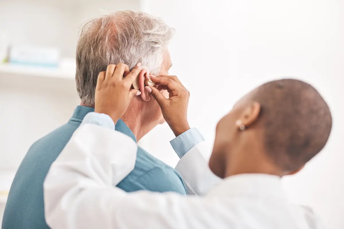 Doctor examining an older man's neck