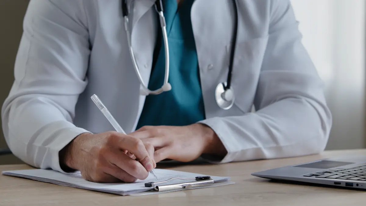 Doctor writing notes at a desk