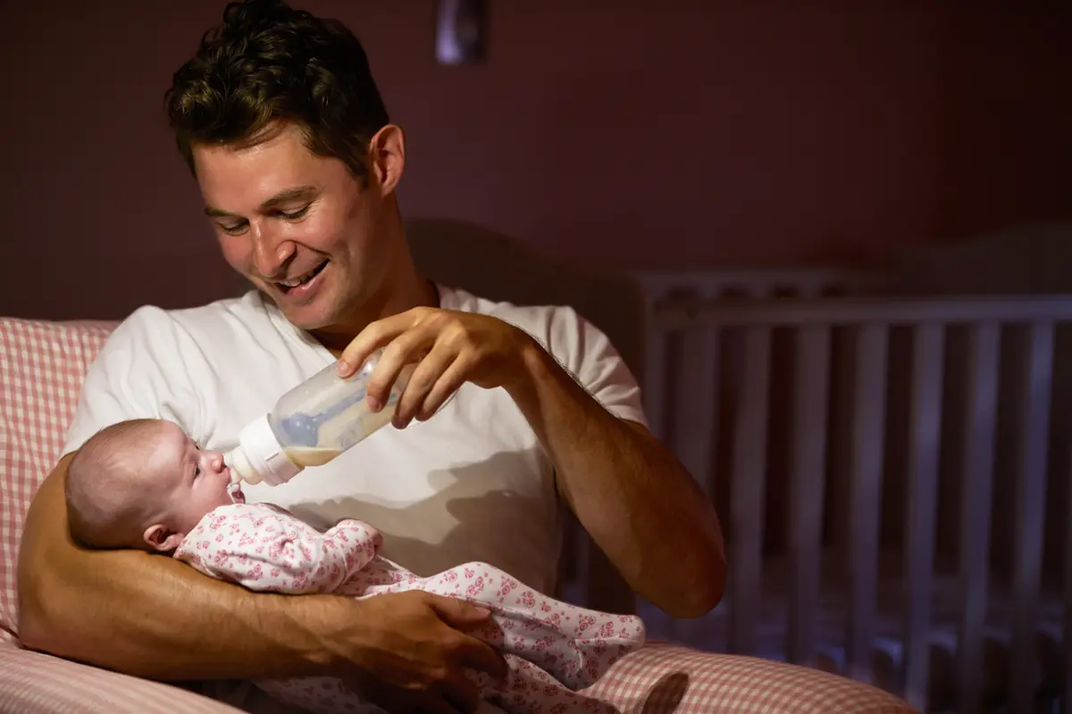 Father feeding his baby a bottle