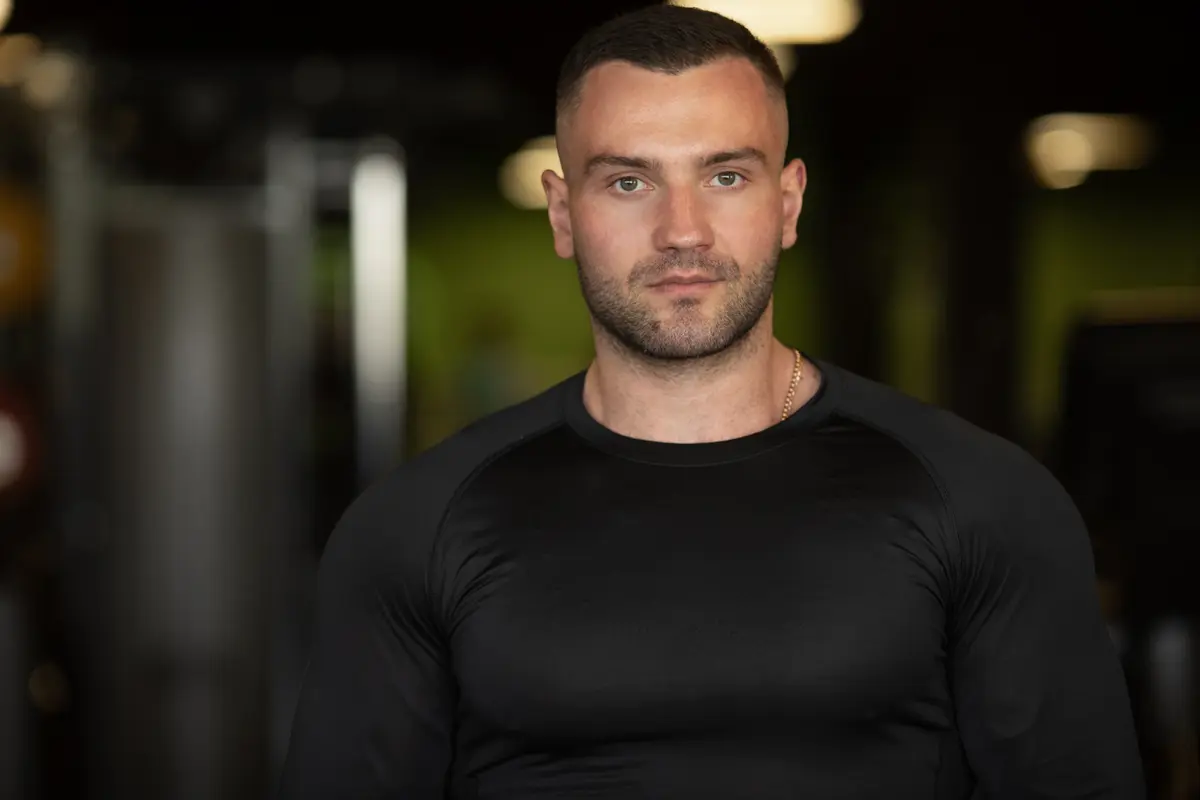 Fit man in a black shirt standing in a gym