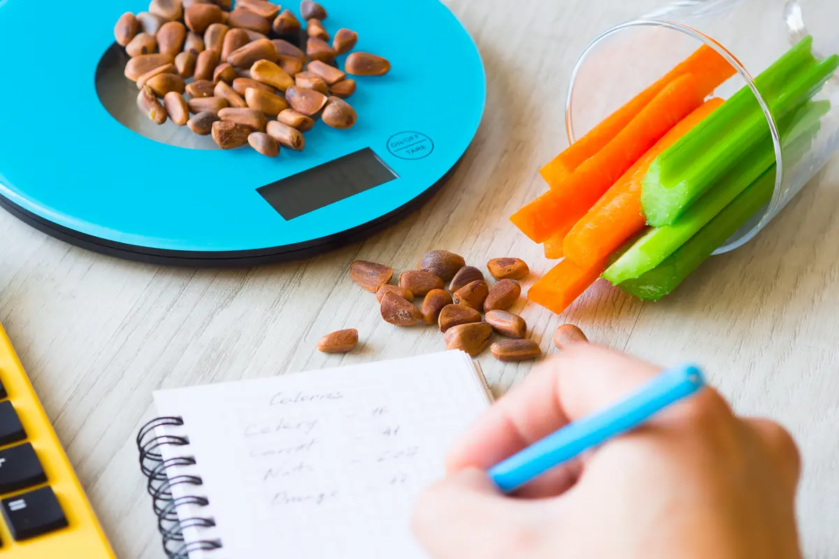 Food diary with a kitchen scale and healthy snacks