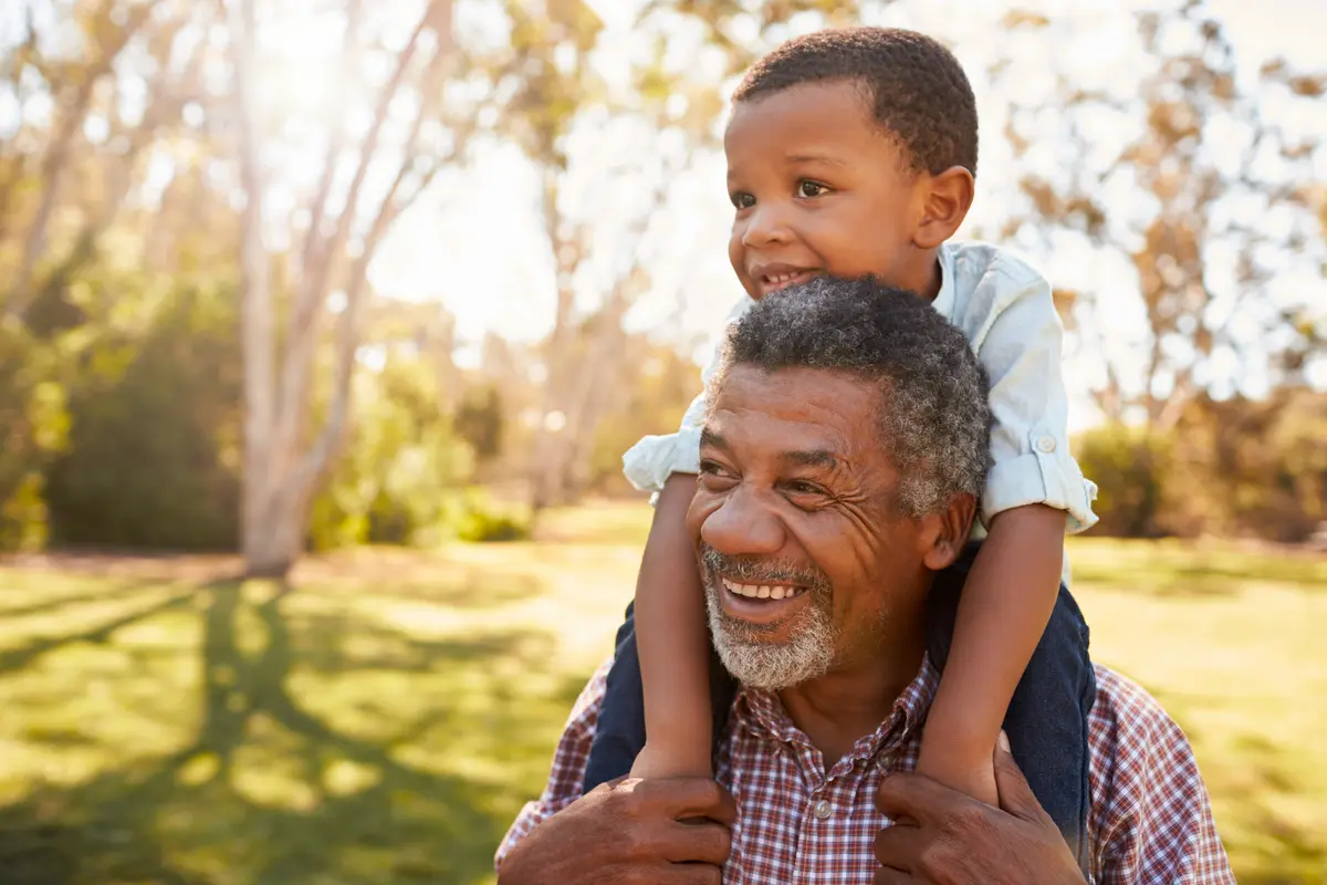 Grandfather carrying his grandson on his shoulders