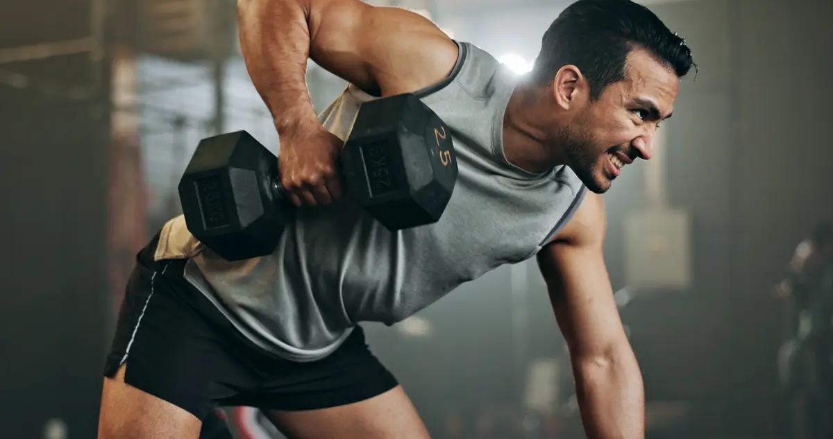 Man doing a heavy dumbbell row in the gym