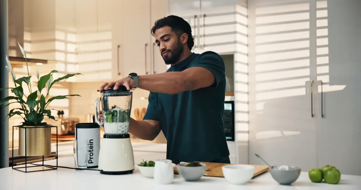 Man making a smoothie in his kitchen