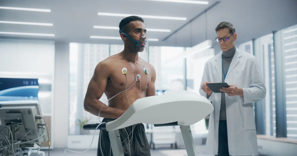 Man on a treadmill stress test with a doctor
