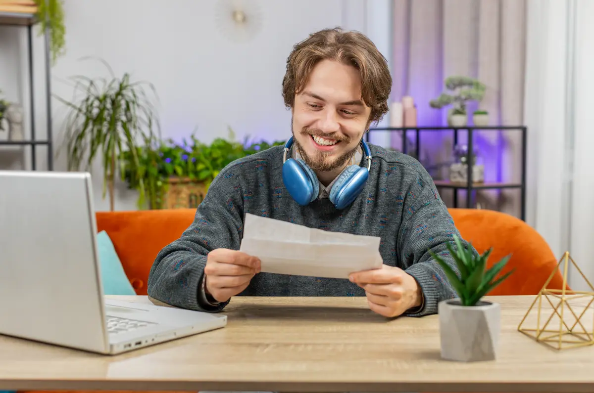 Man reading a letter at his laptop