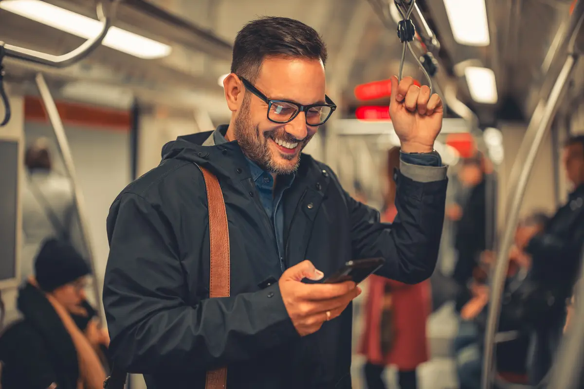 Man reading his phone on a train