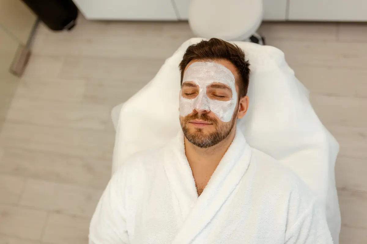 Man relaxing with a facial mask at a spa