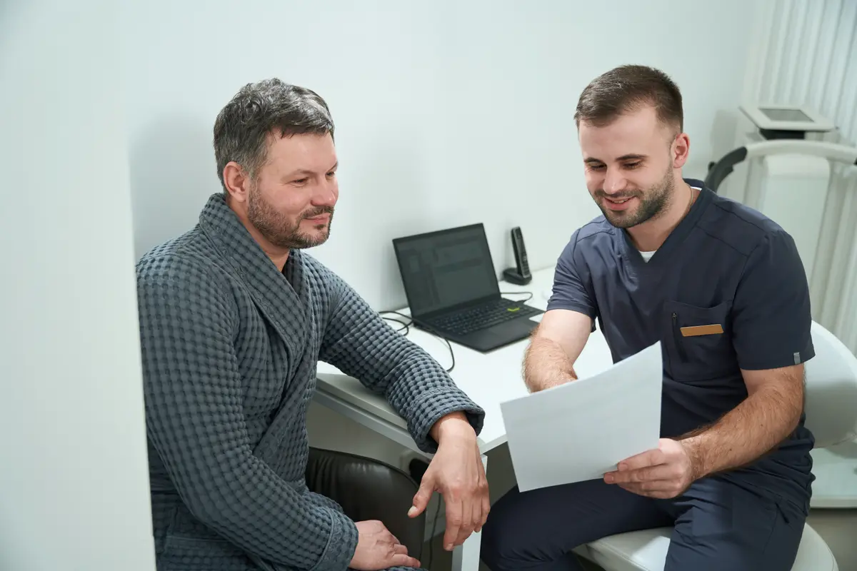 Man reviewing a report with a clinician