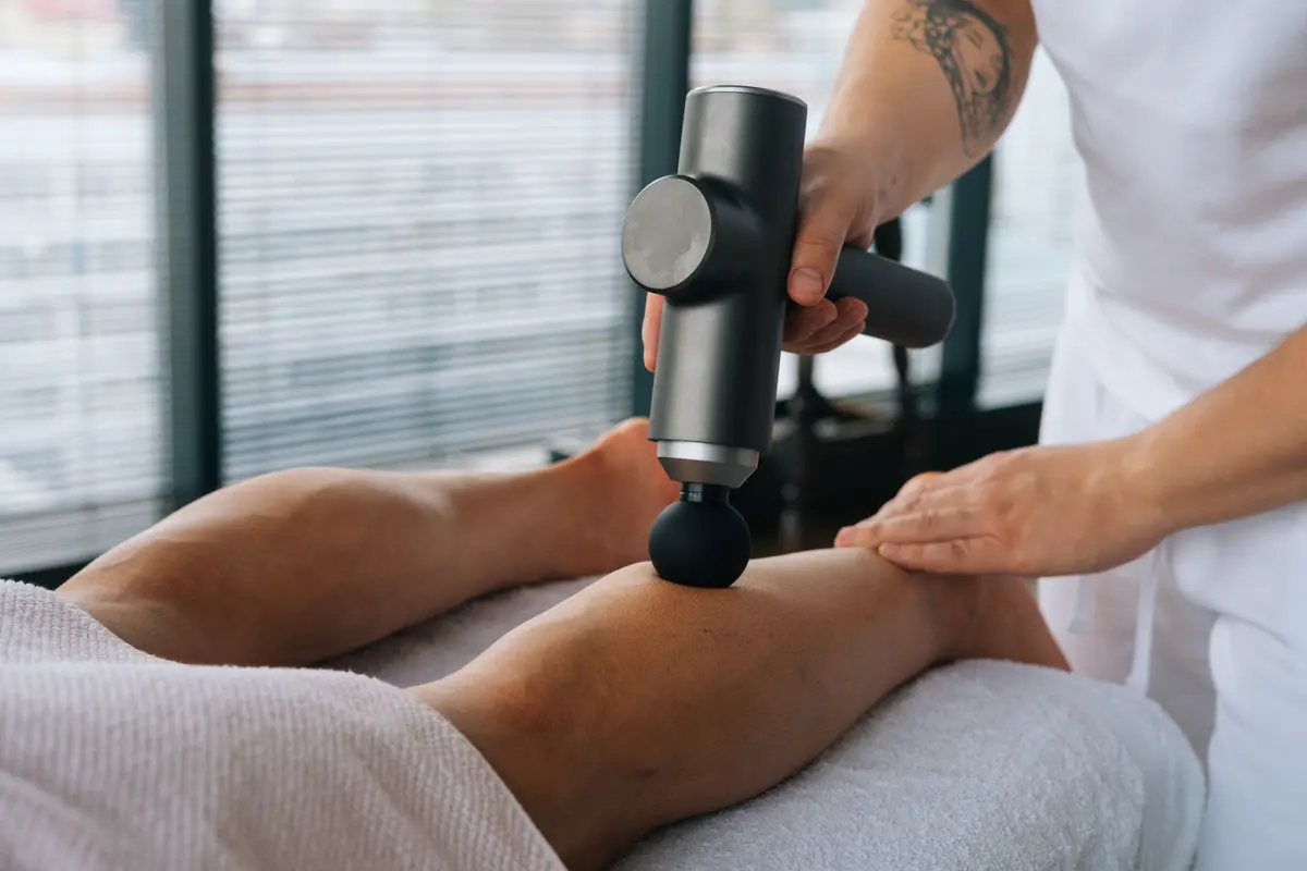 Massage gun used on a leg