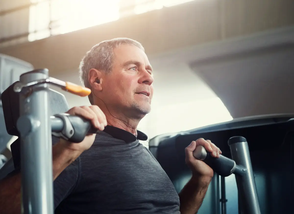 Mature man using a chest press machine at the gym
