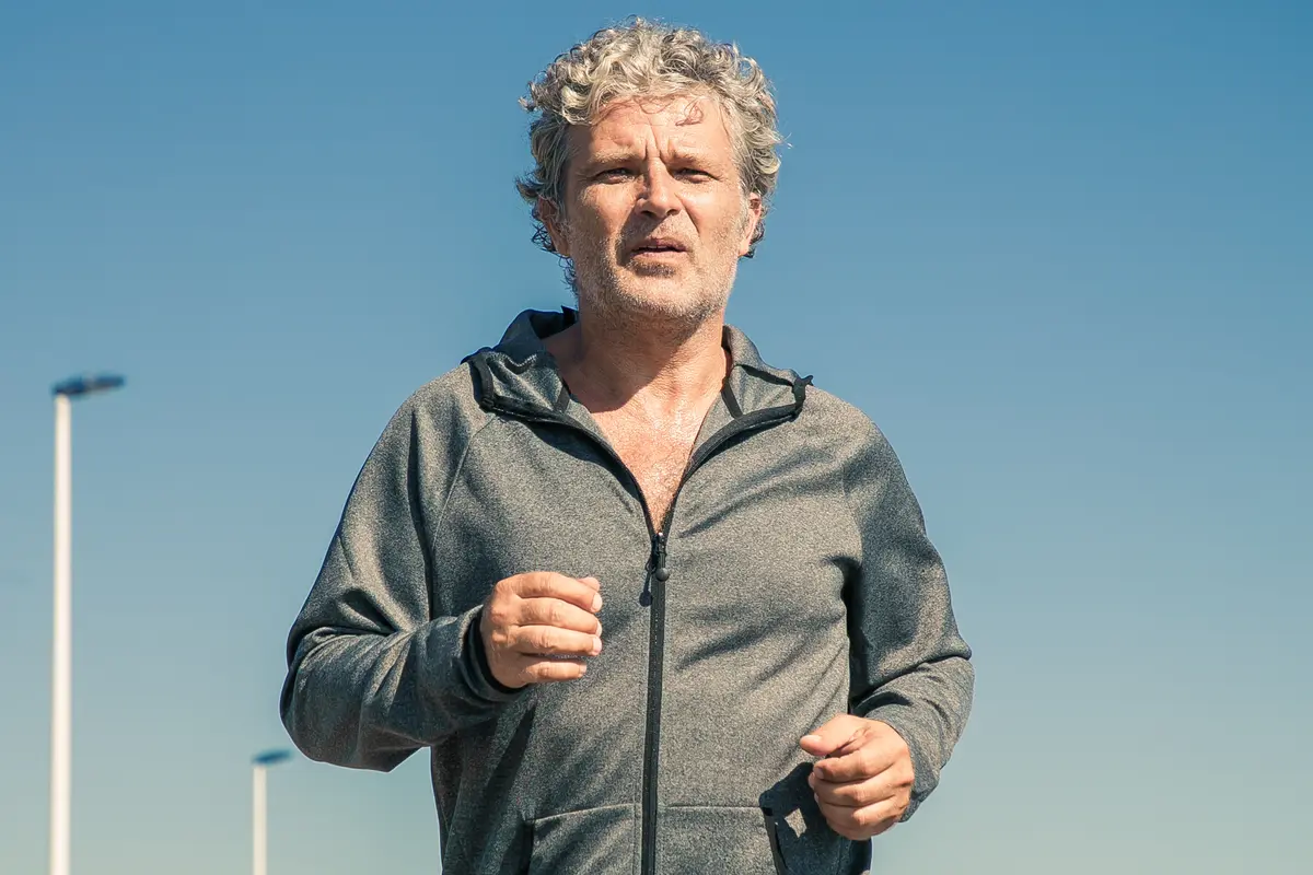 Middle-aged man jogging outdoors on a clear day