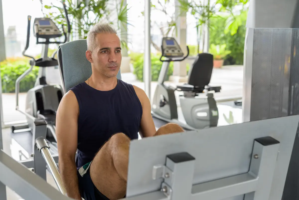 Middle-aged man training on a leg press machine