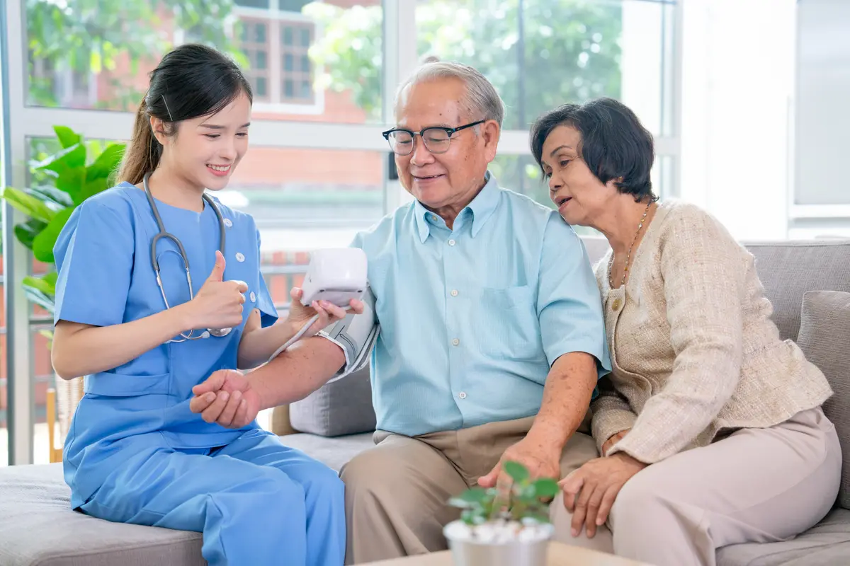 Nurse checking an older man's blood pressure