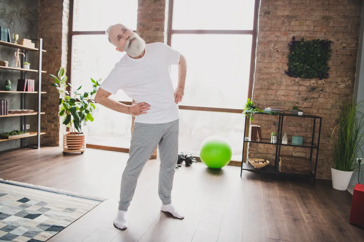 Older man holding his lower back