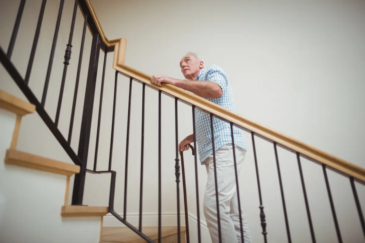 Older man pausing on a staircase