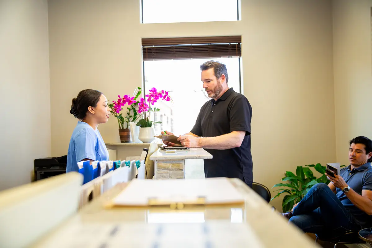 Patients checking in at a clinic front desk