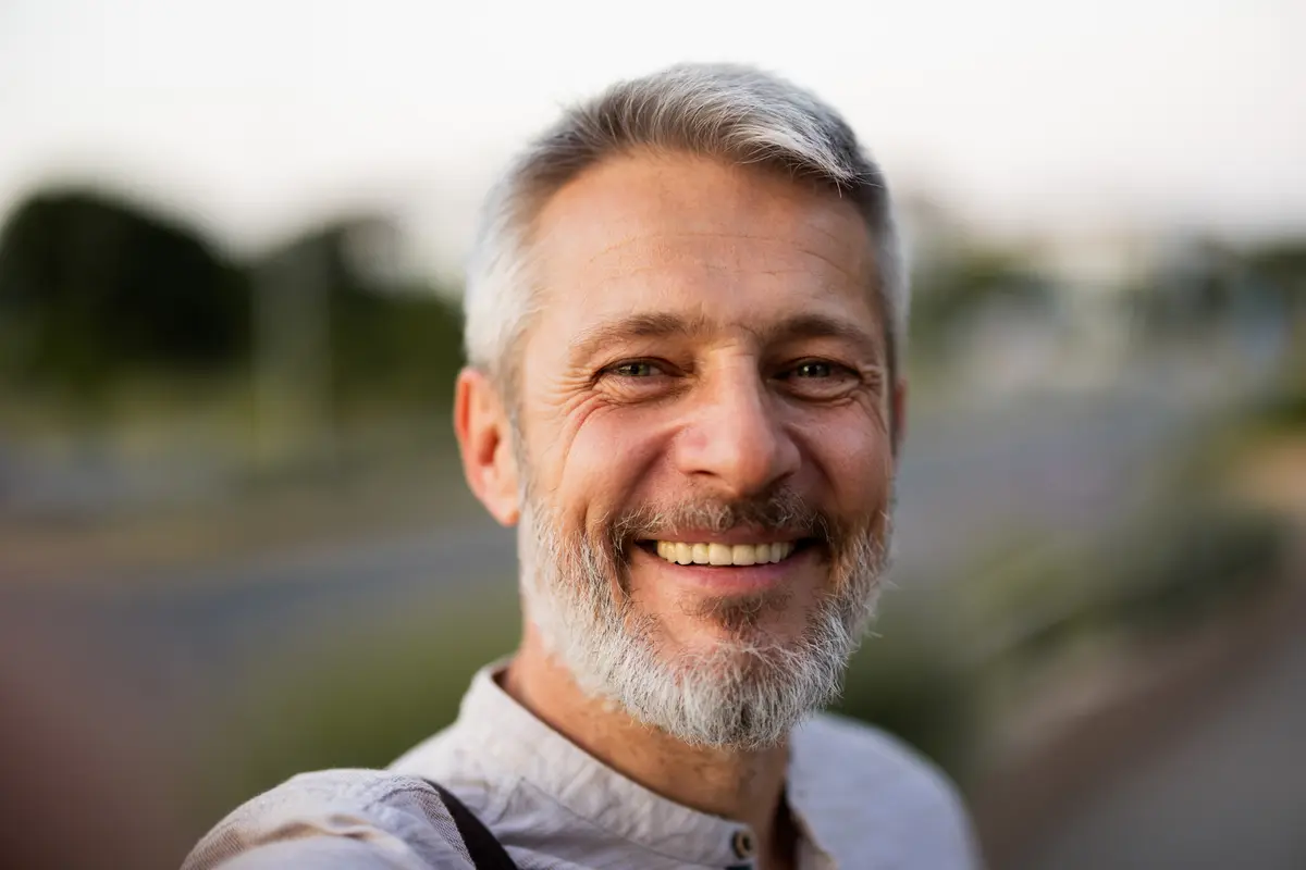 Smiling gray-haired man outdoors