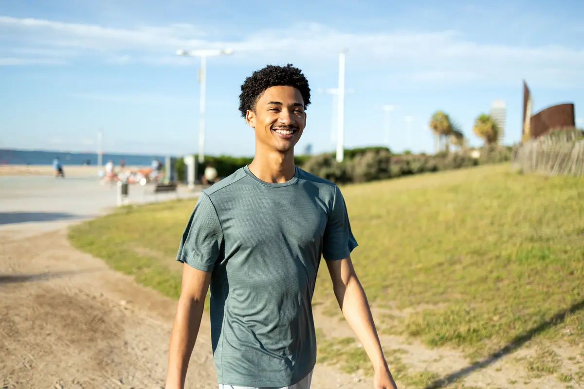 Smiling man walking along the beach
