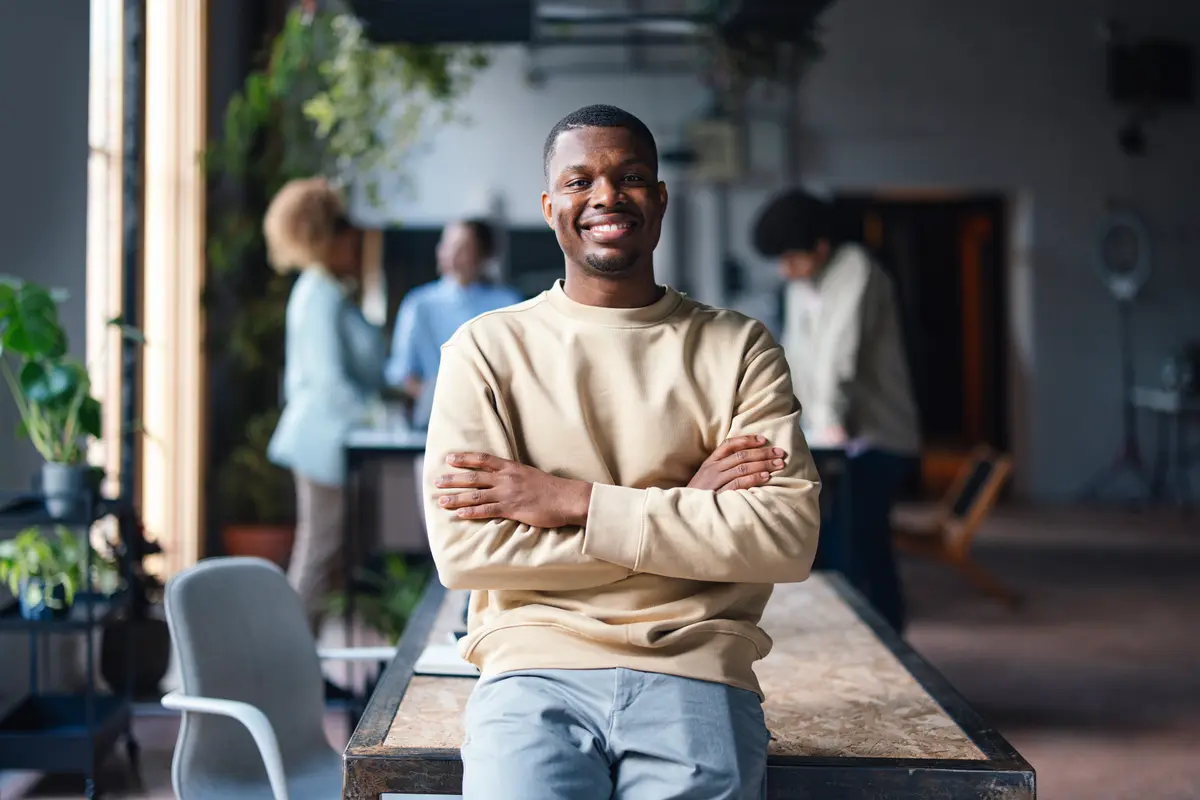 Smiling man with crossed arms in an office