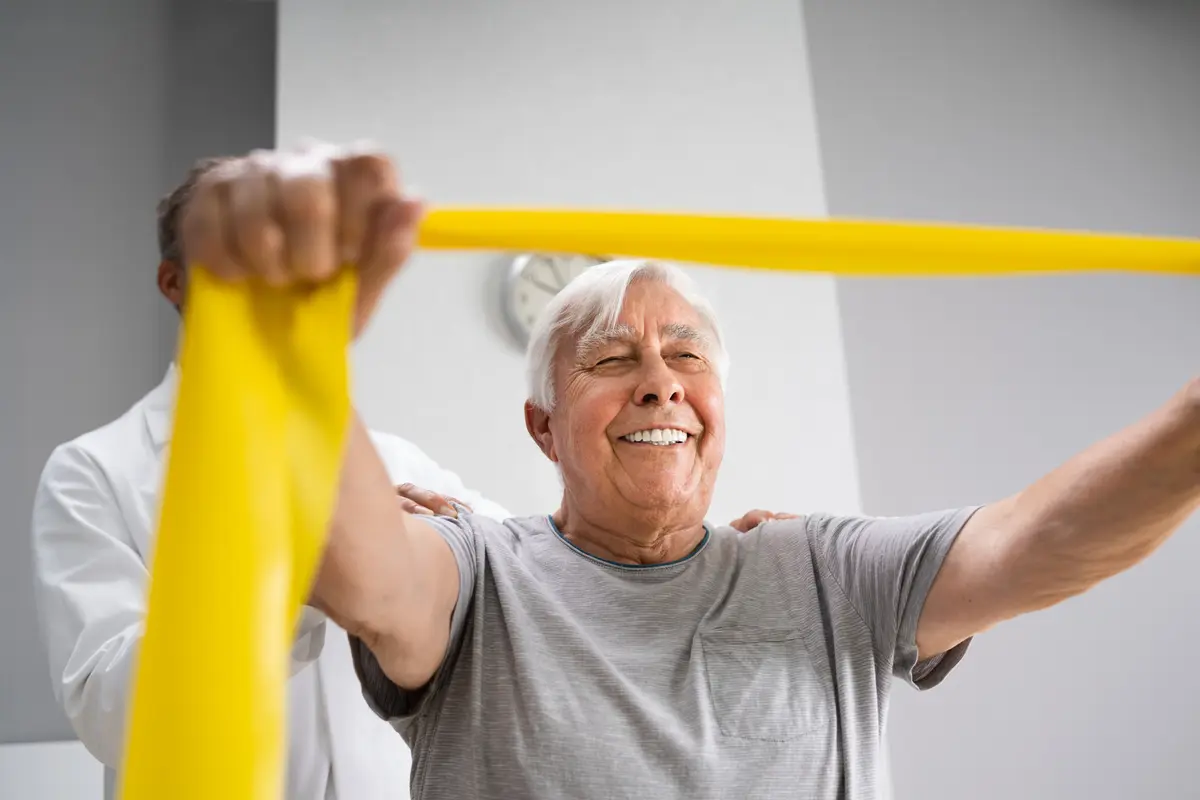 Smiling older man stretching a resistance band