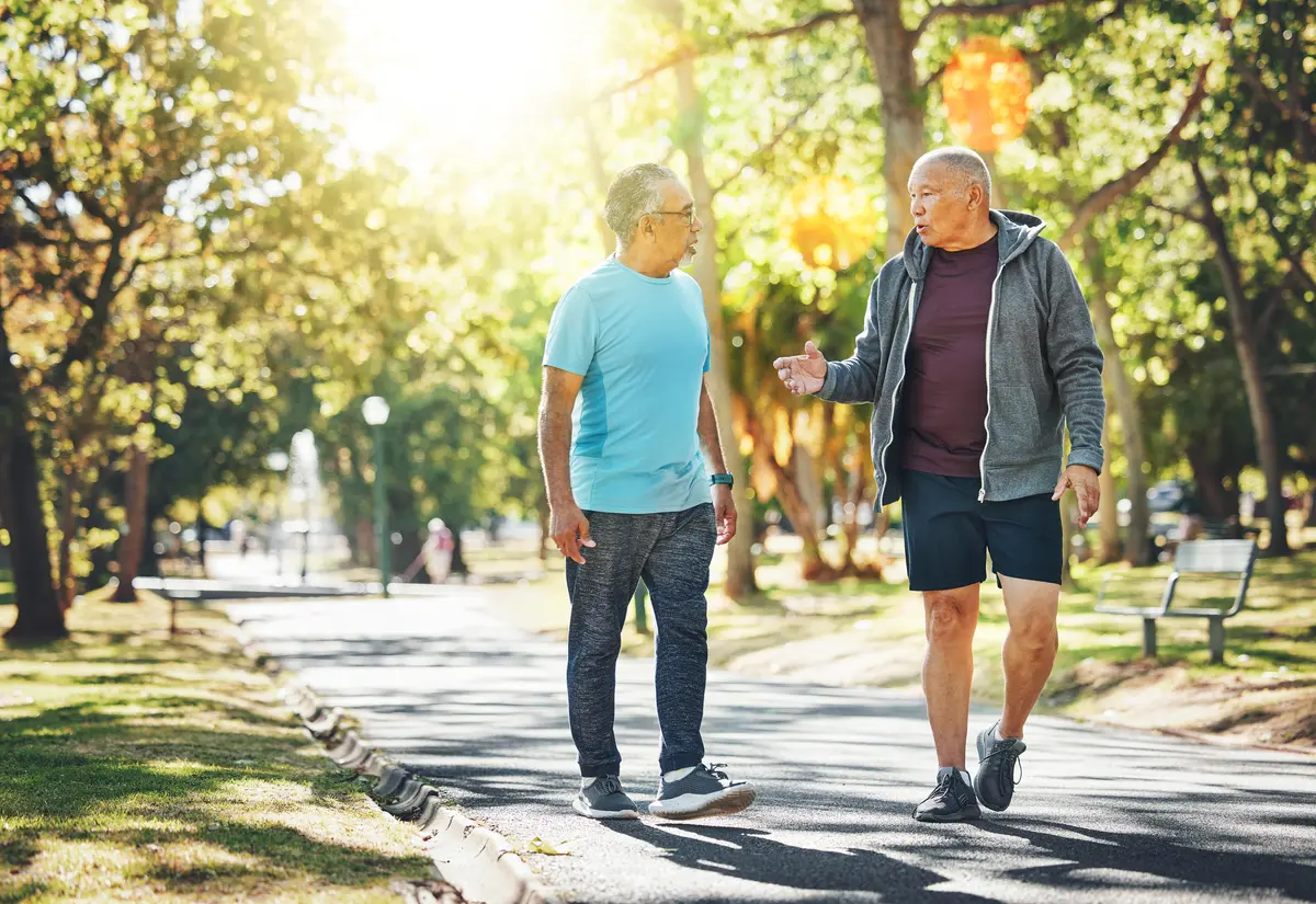 Two older men walking and talking in a park
