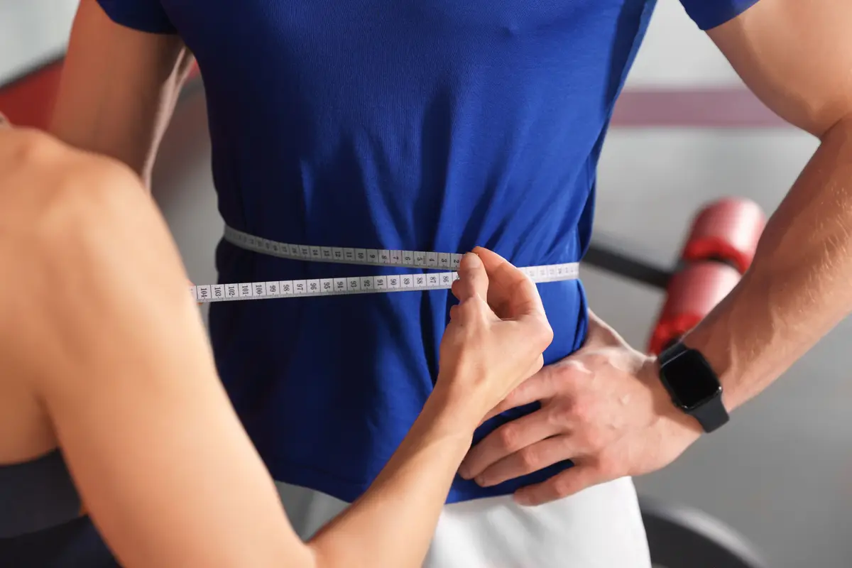 Waist measurement with a tape at the gym